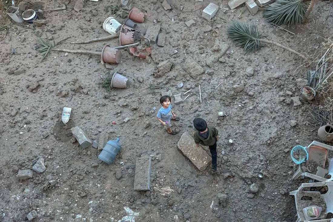 A Palestinian boy stands on the debris of his family's destroyed house.