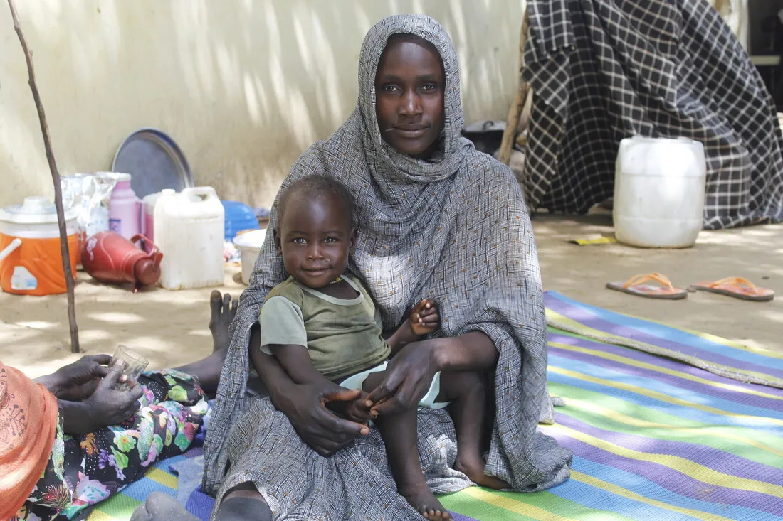 A woman and her months-old baby rest outside a CARE-supported clinic in Chad.